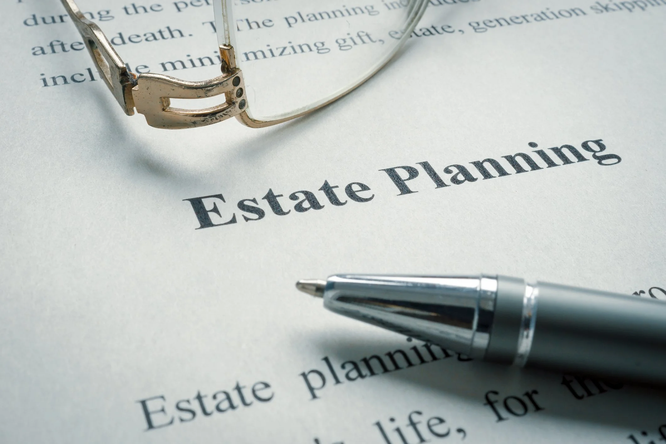 Estate planning documents with a pen and reading glasses