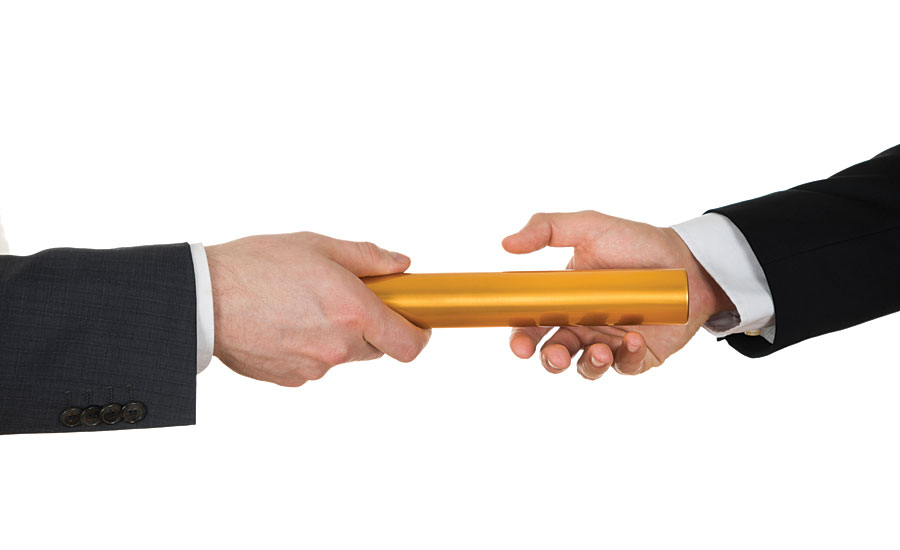 A gold baton passing between two people
